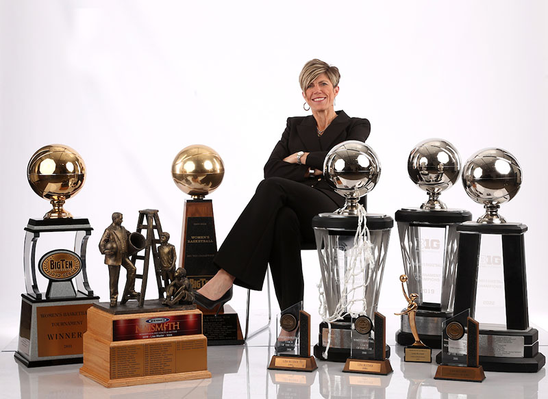 Associate Coach Jensen sits among the many trophies of the Iowa Women's Basketball team