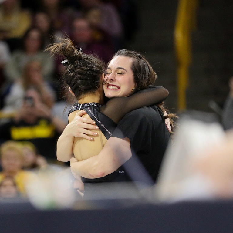 Volunteer assistant coach Rachel David hugs a female gymnast in celebration